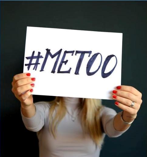 A lady holding a note saying #MeToo